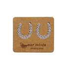 Pair of silver-tone horseshoe stud earrings set with clear cubic zirconia, on an Ear Mints card.