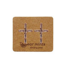 Rose gold-tone cubic zirconia cross stud earrings with baguette stones, on an Ear Mints card