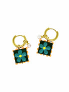 Pair of gold-tone huggie hoops with square dark green tile charms, each with a teal flower, an orange scalloped edge and a small pearl-look bead