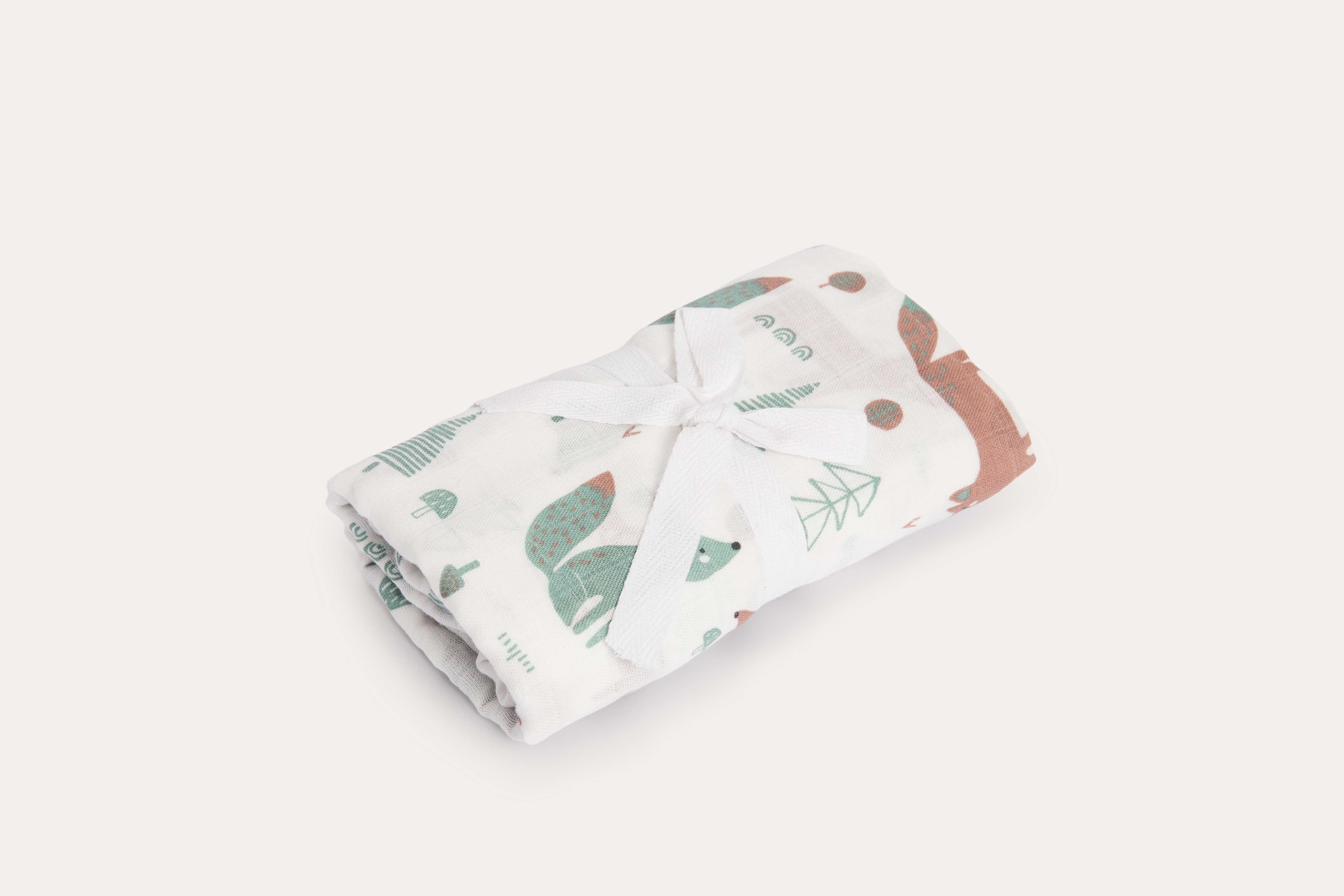 The Foxie muslin wrap rolled and tied with white cotton tape.