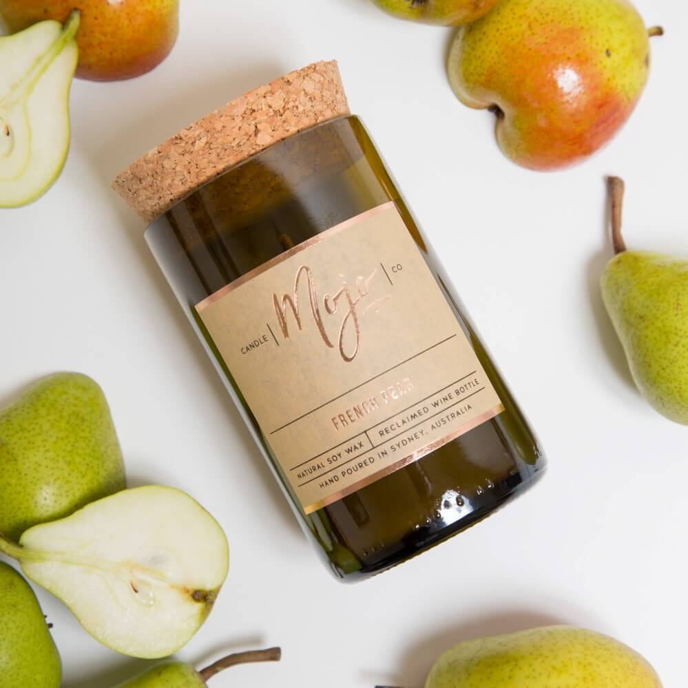 French Pear candle in a cork-topped reclaimed wine bottle overhead with green pears