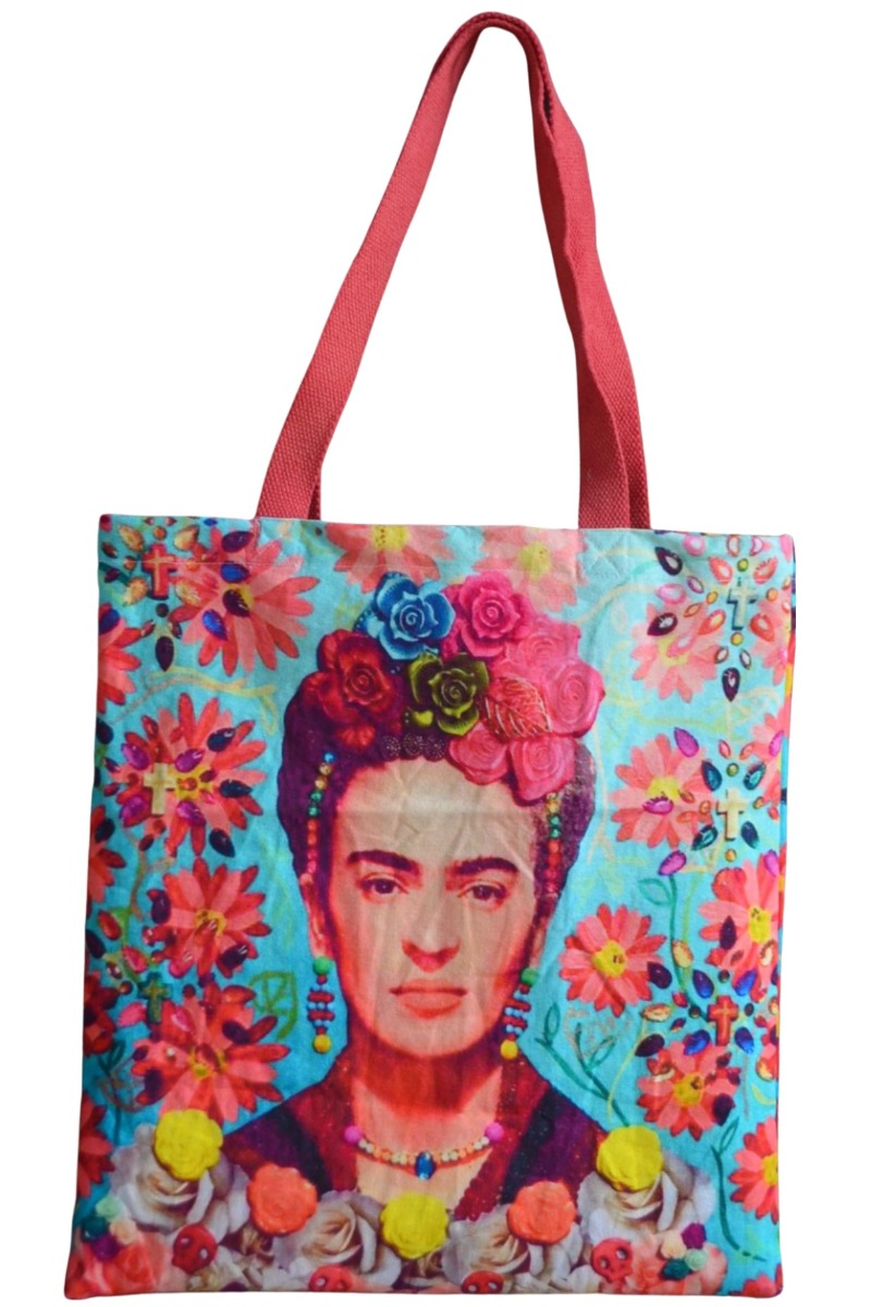 Canvas tote printed with Frida Kahlo, roses in her hair, among coral daisies on turquoise, with long coral-red woven handles