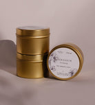 Three gold Geranium travel tins, one tipped forward to show its lid label with a drawing of the geranium.