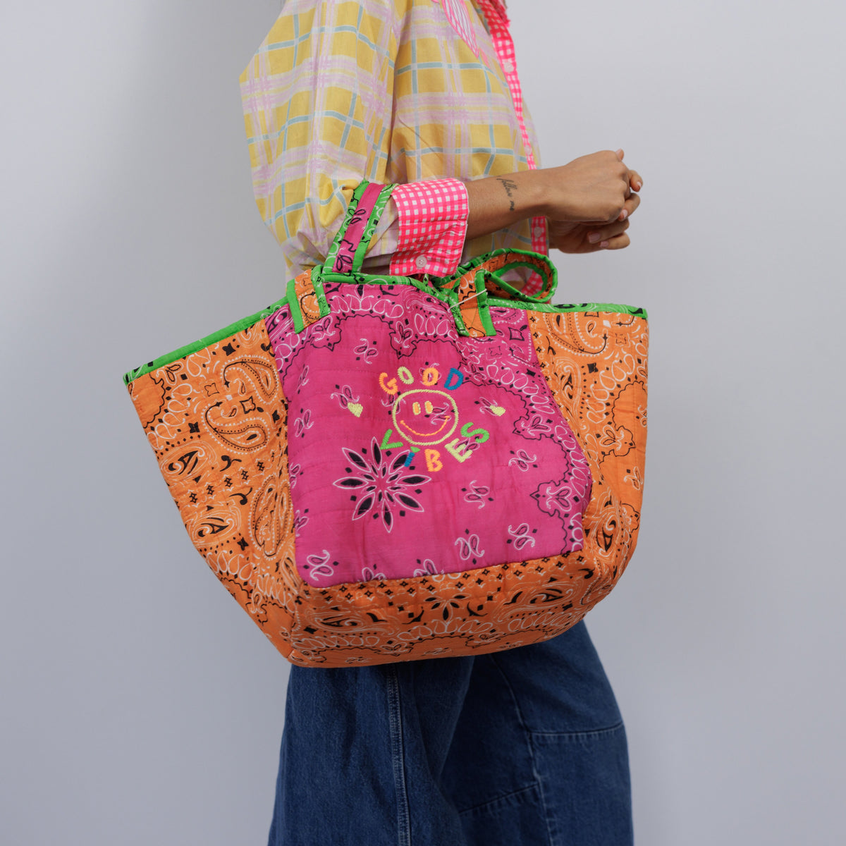Close view of the hot pink front with the embroidered GOOD VIBES smiley above a bandana flower print.
