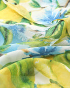 Close-up of the lemon blossom scarf fabric showing the soft watercolour print and frayed edge.