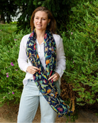 Woman in white shirt and jeans with the navy botanical scarf hanging open down the front.