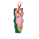 Green Huxter hand cream box with a circle-patterned bauble and a pink circle on the front, and a pink ribbon loop.