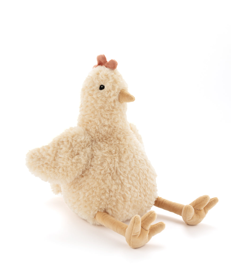 Plush hen in shaggy honey-coloured fur with a red comb and long golden legs, sitting with her legs out in front.