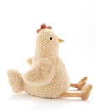 The hen sitting side-on, her long golden legs stretched out in front.