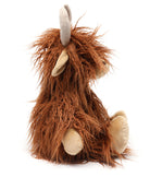 Side view of the cow, its long fur falling over its face and down its back.