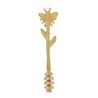 Gold brass honey dipper with a bee on top of a leafy stem and a ridged dipper at the base.