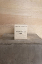 The boxed Hydrangea candle on a concrete plinth.