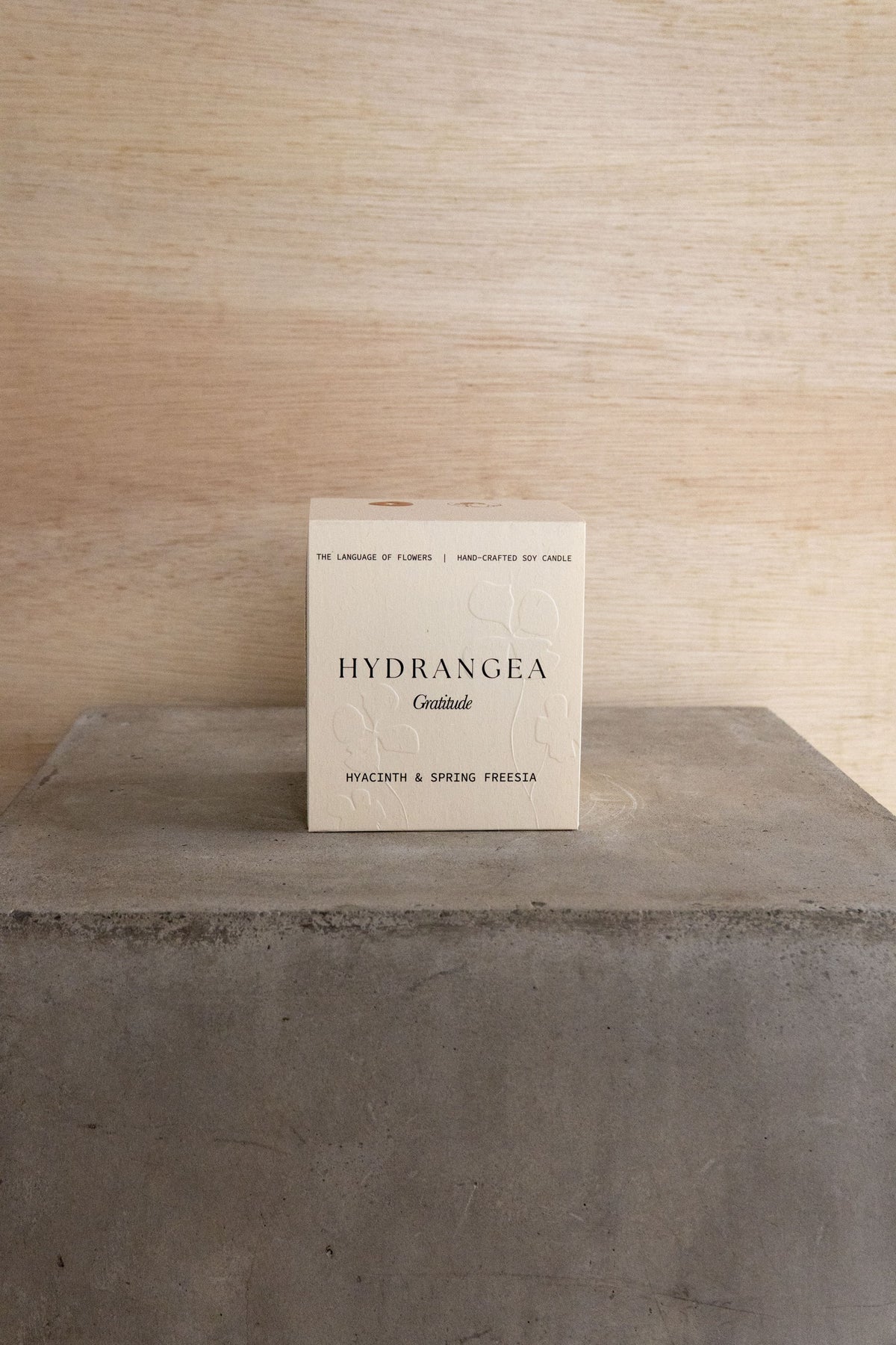 The boxed Hydrangea candle on a concrete plinth.
