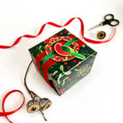 The King Parrot ornament tied with red ribbon onto a wrapped gift.
