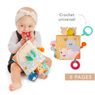 Baby in a headband sitting and chewing the book's red teething ring, with the universal hook and eight pages captioned beside.