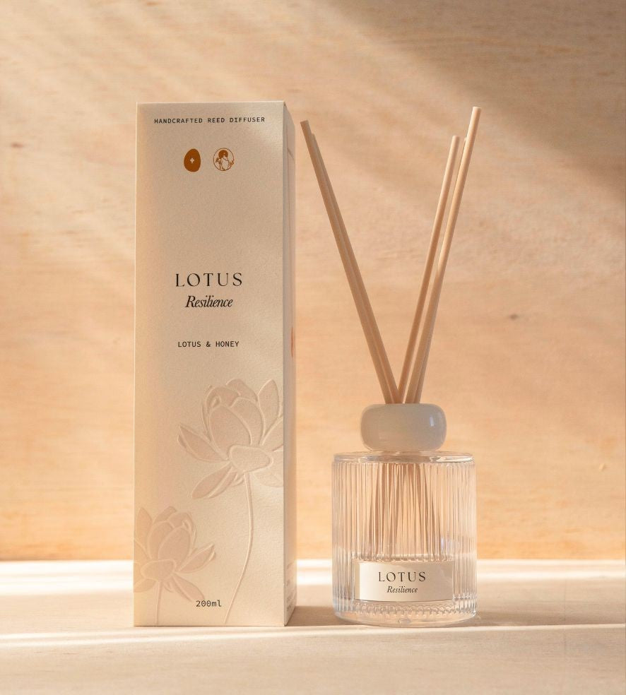 The Lotus reed diffuser, a ribbed glass bottle with natural reeds, beside its cream box.