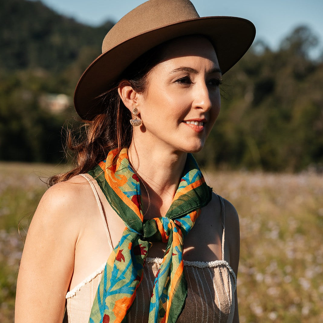 Lucy scarf knotted at the neck, worn with a straw hat