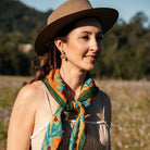 Lucy scarf knotted at the neck, worn with a straw hat