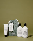 The drawstring bag with the three products standing around it on an olive backdrop.