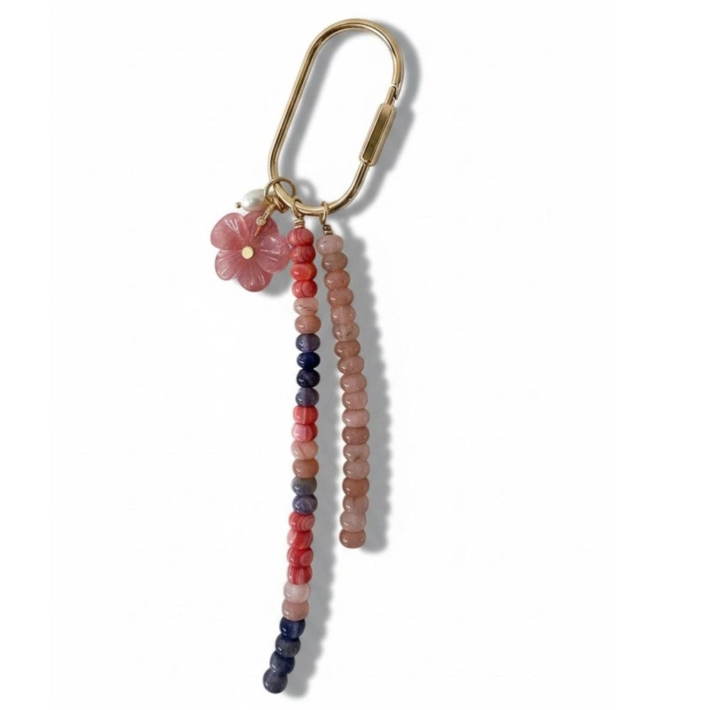 Gold carabiner keyring with a strand of coral, peach and navy stone beads, a strand of peach pink beads and a pink flower charm