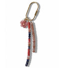 Gold carabiner keyring with a strand of coral, peach and navy stone beads, a strand of peach pink beads and a pink flower charm