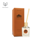 Rangelands Sandalwood Fragrance Diffuser in a glass bottle with a gold top and reeds, beside its orange box