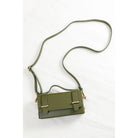 The khaki clutch laid flat with its long shoulder strap attached.