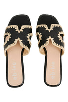 Pair of black Maris slides from above, cream zigzag stitching around the cut-out straps and blush and black footbeds