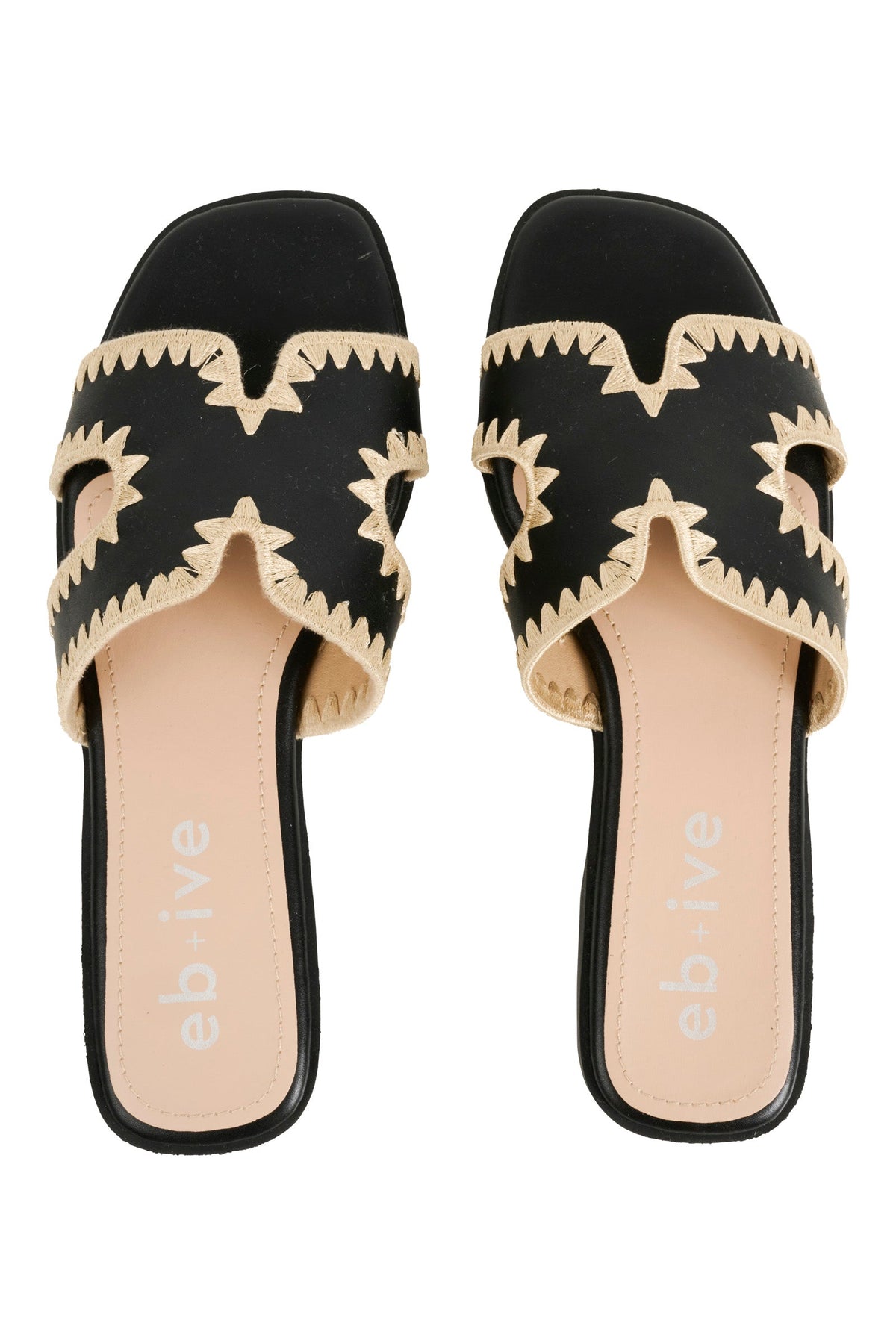 Pair of black Maris slides from above, cream zigzag stitching around the cut-out straps and blush and black footbeds