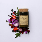 Violet & Frosted Berries soy candle in a cork-topped reclaimed wine bottle with berries, violets and vanilla pods