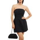 Model in the black strapless dress carrying the clutch low at her side by its chain