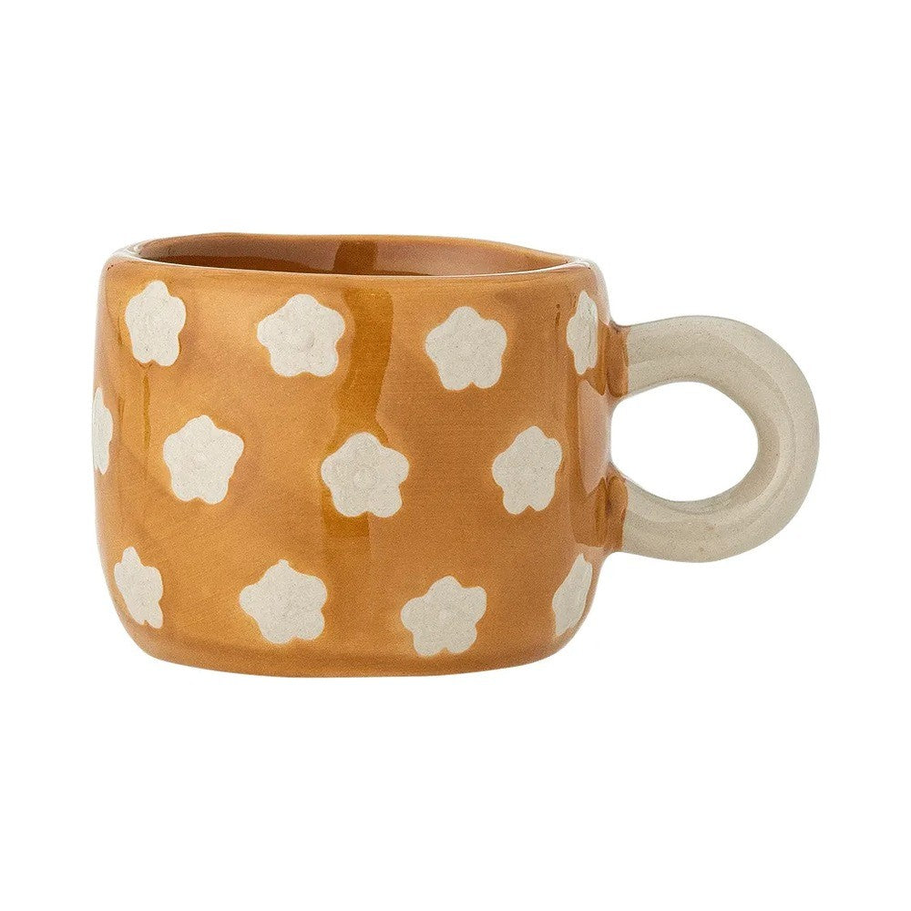 Mustard stoneware cup painted with small white flowers, with a round cream handle