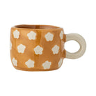 Mustard stoneware cup painted with small white flowers, with a round cream handle