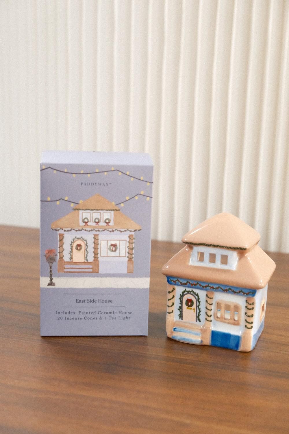 The East Side House holder beside its box on a timber table.
