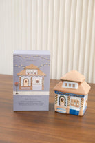 The East Side House holder beside its box on a timber table.