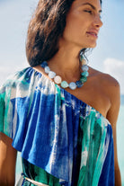 Model in a blue and green one-shoulder top wearing the Palmera Seafoam beaded necklace