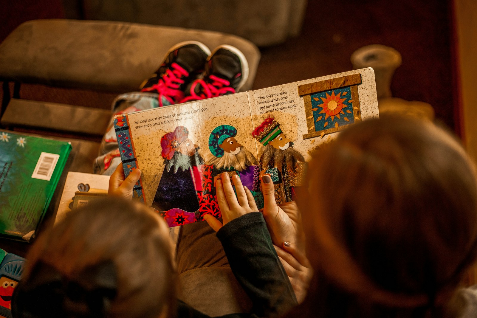 Children reading an open picture book together in warm golden light