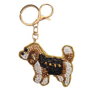Beaded keyring shaped like a tan and white puppy wearing a black coat with gold studs, on a gold-tone clip and ring.