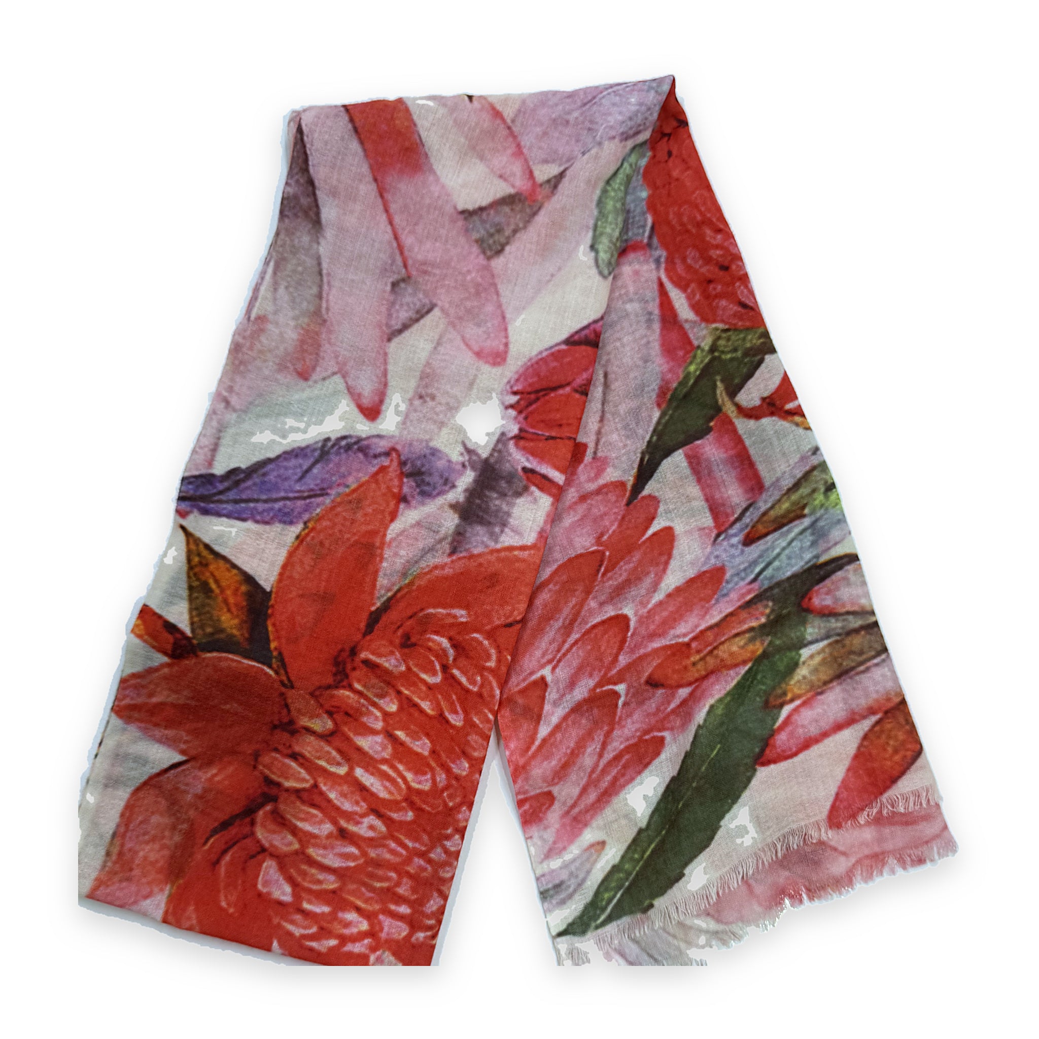 A merino wool scarf laid flat and folded in half, printed with red waratah and torch-ginger flowers among green leaves on a pale pink and cream ground, with a fringed hem.