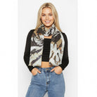 Safari Palm silk scarf worn knotted at the neck with a black top and jeans