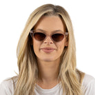 A woman with long blonde hair looking at the camera in the Savannah Blush Pink sunglasses