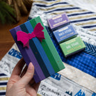 A hand holding the Cool and Clear gift box beside the boxed Sleep, Breathe and Me Time steamers.