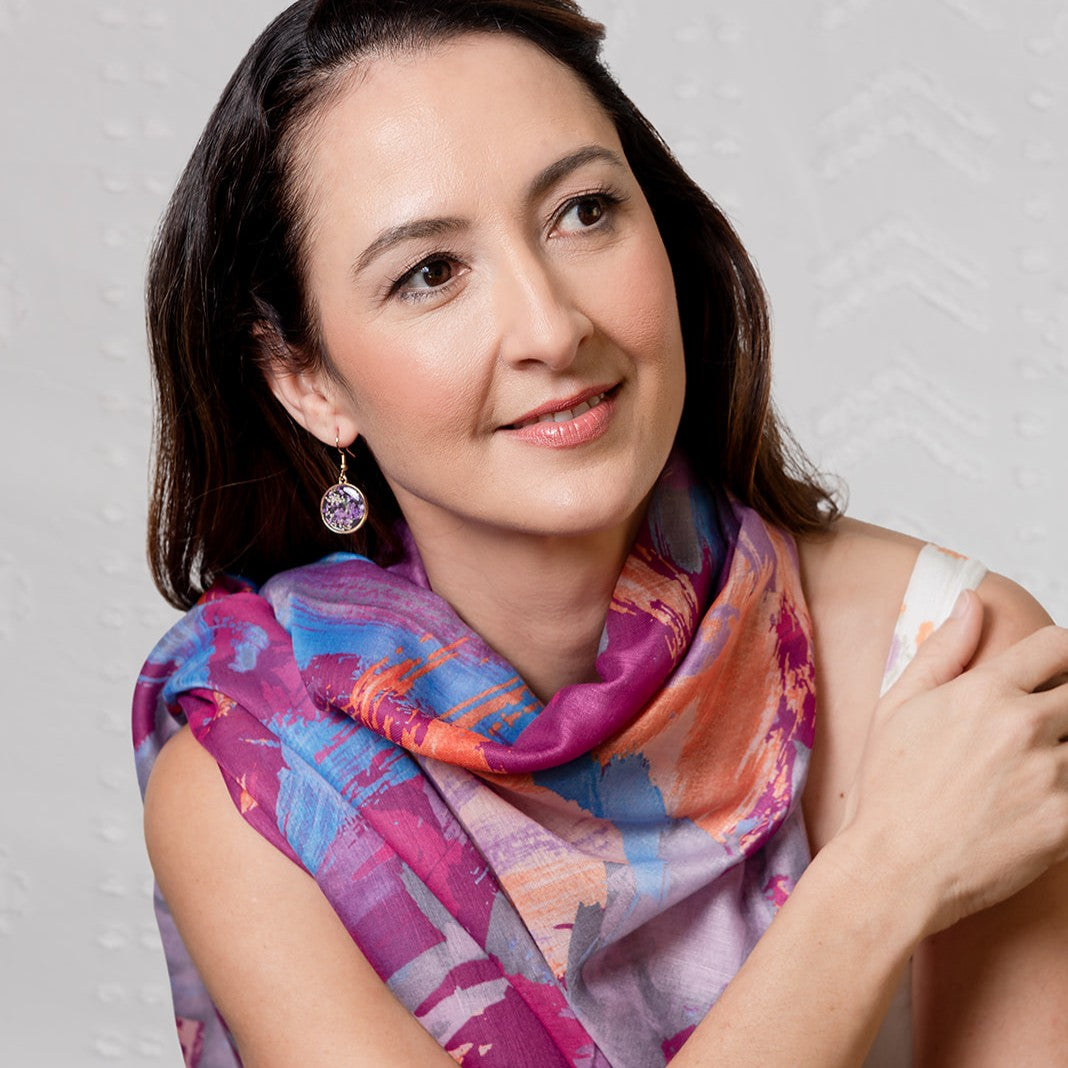 Sunrise scarf in pink worn over the shoulders