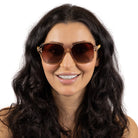 Dark-haired model smiling straight to camera in the Scarlett champagne square sunglasses