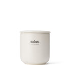 White ceramic Salus candle jar with its matching lid, against white.