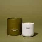The olive gift box beside the lit candle in its white ceramic jar, on an olive backdrop.