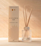 The Sunflower reed diffuser, a ribbed glass bottle with natural reeds, beside its cream box.