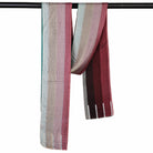 The Sunset Spectrum Stripes scarf hanging over a rail, showing the rose, grey and wine stripes