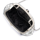The clutch open on its silver frame, showing a black patterned lining