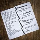 The spiral-bound book open at the Doubled Clinch Knot, with step-by-step drawings.